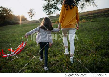 Girl playing with a rainbow hand kite in autumn nature at sunset. 130299804