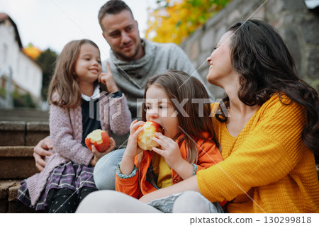 Sisters and parents in park during warm autumn day. 130299818