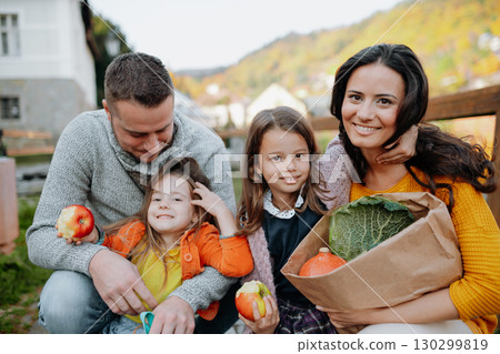 Sisters and parents in park during warm autumn day. 130299819