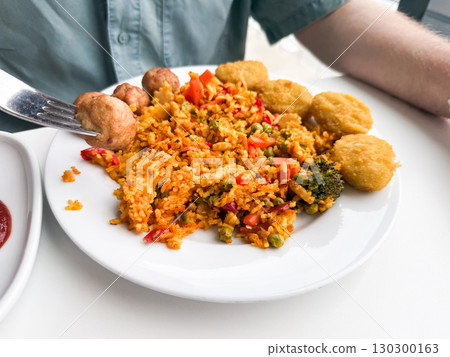 Plate with rice, nuggets and vegetables. Fast food, casual lunch and everyday dining concept. Plate with rice, nuggets and vegetables. Fast food, casual lunch and everyday dining concept. 130300163