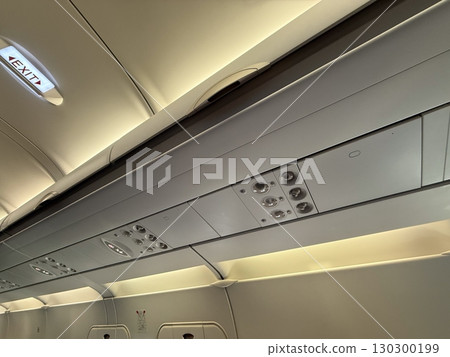 Airplane ceiling panel with lights and air vents. Passenger comfort, aviation technology, and flight interior design. 130300199