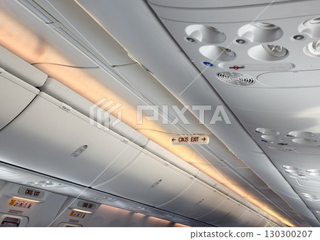 Airplane ceiling panel with lights and air vents. Passenger comfort, aviation technology, and flight interior design. 130300207