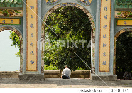 Man sitting next to a gate. 130301185