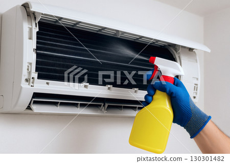 A scene of a person spraying the inside of an air conditioner and cleaning to prevent mold in the summer 130301482