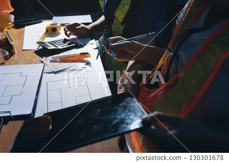 Closeup of team of industrial engineers meeting analyze machinery blueprints consult project on table in manufacturing factory. Working in manufacturing plant or production plant. 130301678
