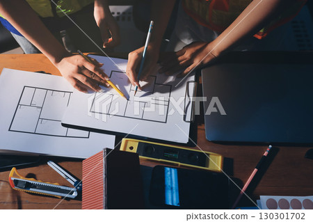 Closeup of team of industrial engineers meeting analyze machinery blueprints consult project on table in manufacturing factory. Working in manufacturing plant or production plant. Closeup of team of industrial engineers meeting analyze machinery blueprints consult project on table in manufacturing factory. Working in manufacturing plant or production plant. 130301702