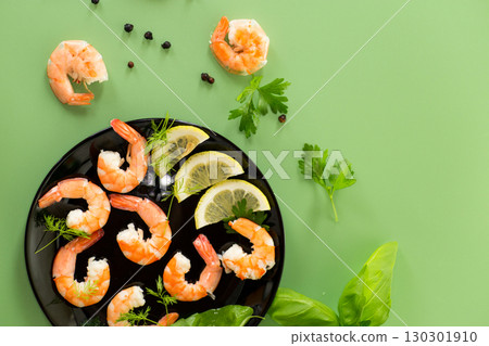 Seafood red shrimps with lemon isolated on green background Seafood red shrimps with lemon isolated on green background 130301910