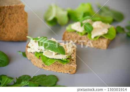 Homemade rye bread with herring paste and arugula 130301914