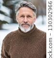 close up portrait of an older man in a brown sweater snow softly. 130302966