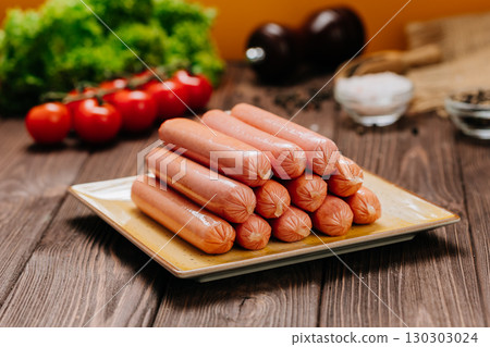 Pile of raw sausages stacked on a ceramic plate, ready for cooking, close-up view Pile of raw sausages stacked on a ceramic plate, ready for cooking, close-up view 130303024