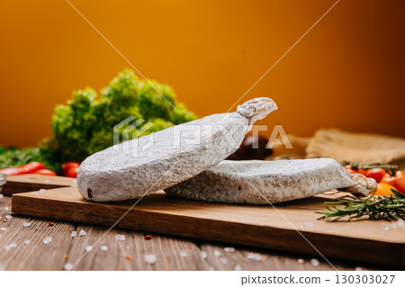 Dry-cured salami on board, ideal for rustic charcuterie presentations and gourmet food styling Dry-cured salami on board, ideal for rustic charcuterie presentations and gourmet food styling 130303027