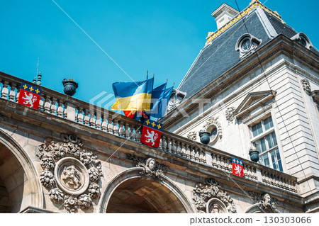 Historic European building with Ukrainian and French flags under a clear blue sky. National identity, Ukraine solidarity, cultural diplomacy, European heritage 130303066
