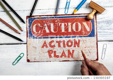 Caution sign warning about business action plan on creative workspace with hand and office tools Caution sign warning about business action plan on creative workspace with hand and office tools 130303197