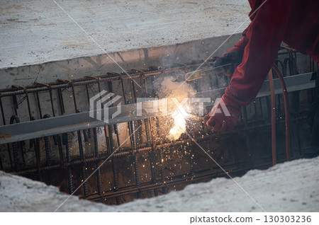 Welders are welding steel at a construction site. 130303236