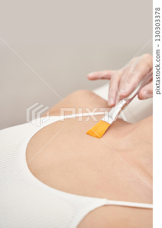 Female receiving spa body treatment with brush for skincare and relaxation Female receiving spa body treatment with brush for skincare and relaxation 130303378