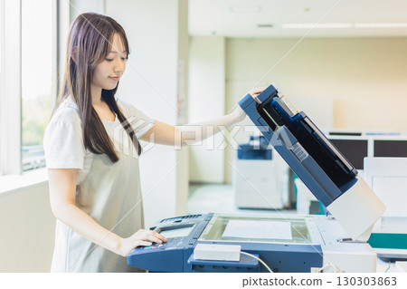 Female employee making a copy Female employee making a copy 130303863