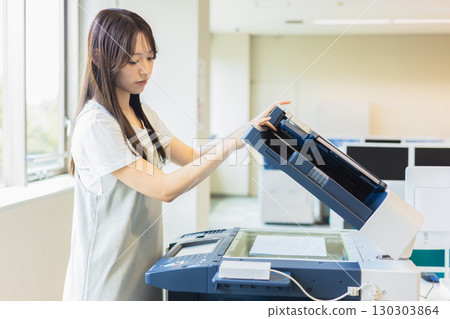 Female employee making a copy Female employee making a copy 130303864