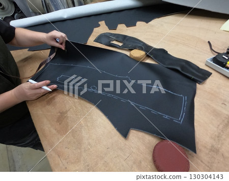 Cutting and preparing black leather or synthetic material for custom car interior 130304143