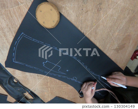 Cutting and preparing black leather or synthetic material for custom car interior Cutting and preparing black leather or synthetic material for custom car interior 130304149