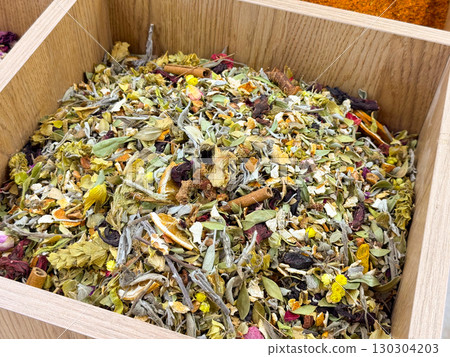 Herbal tea blend with dried flowers, leaves, and spices. Wellness tradition, natural remedies and cultural tea preparation heritage. 130304203