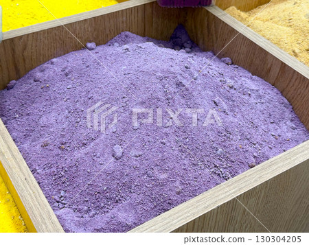 Purple spice powder in wooden container. Exotic culinary ingredient, colorful market display, and authentic cooking tradition. 130304205
