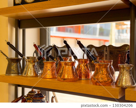 Copper and brass Turkish coffee pots with engraved designs. Traditional coffee preparation, cultural heritage, and artisanal craftsmanship. 130304206