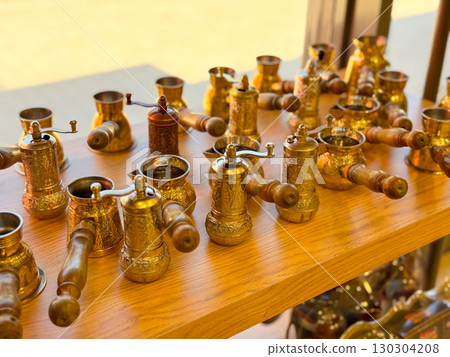 Copper and brass Turkish coffee pots with engraved designs. Traditional coffee preparation, cultural heritage, and artisanal craftsmanship. 130304208
