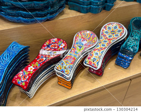 Colorful ceramic spoon rests and decorative bowls. Traditional hand-painted kitchenware, cultural artistry, and vibrant craftsmanship in everyday objects. Colorful ceramic spoon rests and decorative bowls. Traditional hand-painted kitchenware, cultural artistry, and vibrant craftsmanship in everyday objects. 130304214