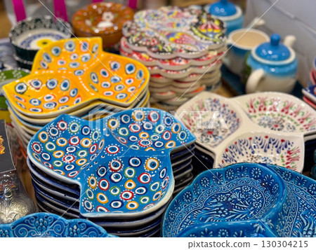 Colorful ceramic spoon rests and decorative bowls. Traditional hand-painted kitchenware, cultural artistry, and vibrant craftsmanship in everyday objects. 130304215