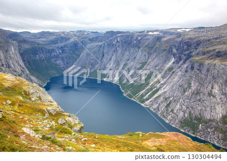 Dramatic fjord landscape in Norway showcasing towering cliffs and serene waters 130304494
