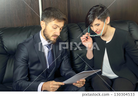 Business professionals discussing project details in an office setting during daytime Business professionals discussing project details in an office setting during daytime 130304533
