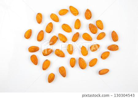Almonds scattered on a clean white surface for a healthy snack or recipe inspiration Almonds scattered on a clean white surface for a healthy snack or recipe inspiration 130304543