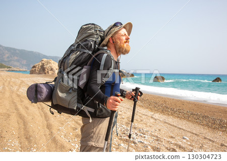 Hiker enjoys a moment of solitude on a tranquil beach in Turkey with scenic ocean view 130304723