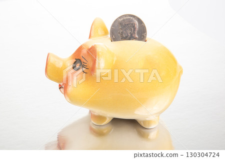 Colorful piggy bank with a quarter ready for saving money in a bright indoor setting 130304724