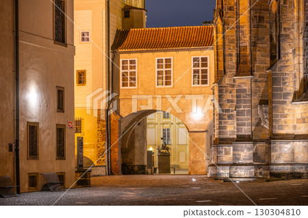 A beautifully illuminated covered bridge at Saint Vitus Cathedral, part of Prague Castle, enhances the nighttime charm of this historic location. 130304810