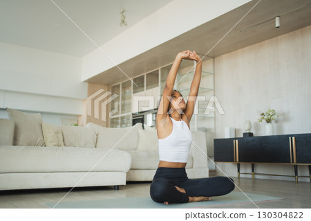 Yoga fitness workout training. Healthy African girl practicing yoga at home. Woman training Pilates doing sports exercise on yoga mat indoor. Girl have training workout for weight loss. Sport fitness Yoga fitness workout training. Healthy African girl practicing yoga at home. Woman training Pilates doing sports exercise on yoga mat indoor. Girl have training workout for weight loss. Sport fitness 130304822