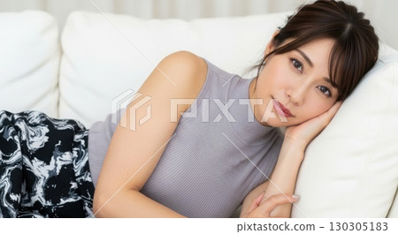 A beautiful woman lying on a sofa at home, gazing gently at you A beautiful woman lying on a sofa at home, gazing gently at you 130305183