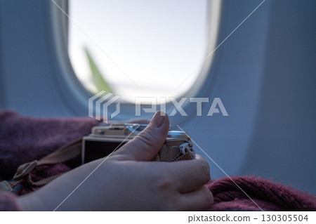 飛機上拿著相機的女人的手 130305504