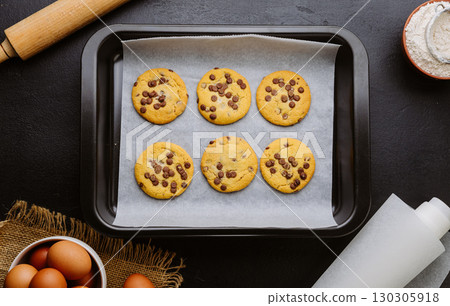 Golden brown chocolate chip cookies cooling on tray, perfect homemade sweet snack Golden brown chocolate chip cookies cooling on tray, perfect homemade sweet snack 130305918