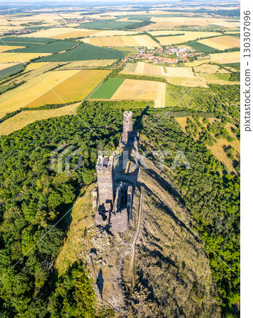 Hazmburk Castle ruins rise dramatically over the lush Central Bohemian Uplands. This medieval site showcases stunning architecture and breathtaking aerial views of the surrounding landscape. Hazmburk Castle ruins rise dramatically over the lush Central Bohemian Uplands. This medieval site showcases stunning architecture and breathtaking aerial views of the surrounding landscape. 130307096