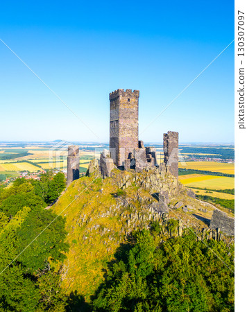 Hazmburk Castle ruins rise majestically in the Central Bohemian Uplands. Visitors can enjoy stunning aerial views of the landscape and surrounding hills during clear weather. 130307097