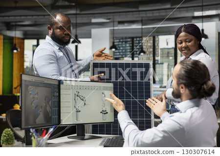 Engineering team doing brainstorming to optimize sustainable solar panel fabrication with advanced assembly lines. Teamworking colleagues innovate clean solar energy manufacturing processes 130307614