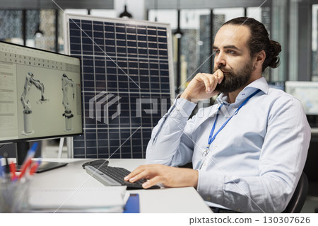 Engineer designs solar panels using CAD software, enhancing efficiency and reducing environmental impact. Green energy facility worker develops robotic arm systems for automated solar cells production Engineer designs solar panels using CAD software, enhancing efficiency and reducing environmental impact. Green energy facility worker develops robotic arm systems for automated solar cells production 130307626