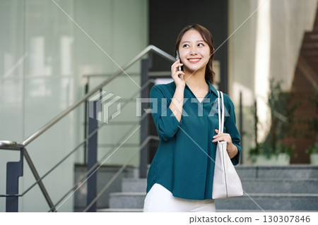 一位年輕的職業女性在智慧型手機上交談 130307846