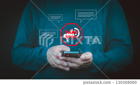 Fake News concept. Person holding a smartphone with a red "FAKE NEWS" warning icon surrounded by chat bubbles, symbolizing misinformation online, manipulate opinion on internet and social media. Fake News concept. Person holding a smartphone with a red "FAKE NEWS" warning icon surrounded by chat bubbles, symbolizing misinformation online, manipulate opinion on internet and social media. 130308000