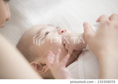 年輕的母親照顧她的孩子 年輕的母親照顧她的孩子 130308059
