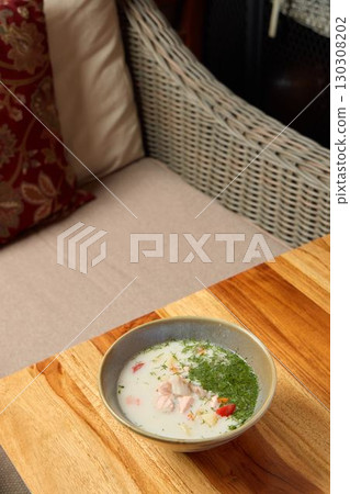 A Delicious Bowl of Soup, Beautifully Topped with Fresh Herbs and Colorful Seasonal Vegetables A Delicious Bowl of Soup, Beautifully Topped with Fresh Herbs and Colorful Seasonal Vegetables 130308202