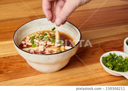 Enhancing a Flavorful Sauce Presentation by Garnishing with Fresh Green Onions for Appeal 130308211