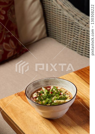 Indulge in a Delicious Bowl of Soup, enhanced with Fresh Herbs and an array of Spices Indulge in a Delicious Bowl of Soup, enhanced with Fresh Herbs and an array of Spices 130308222