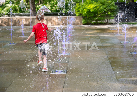 Young boy running through the fountains at the Popup Water Park in St. Louis, Missouri 130308760